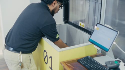 Retail staff handing a finished order to a customer at the Pio workstation